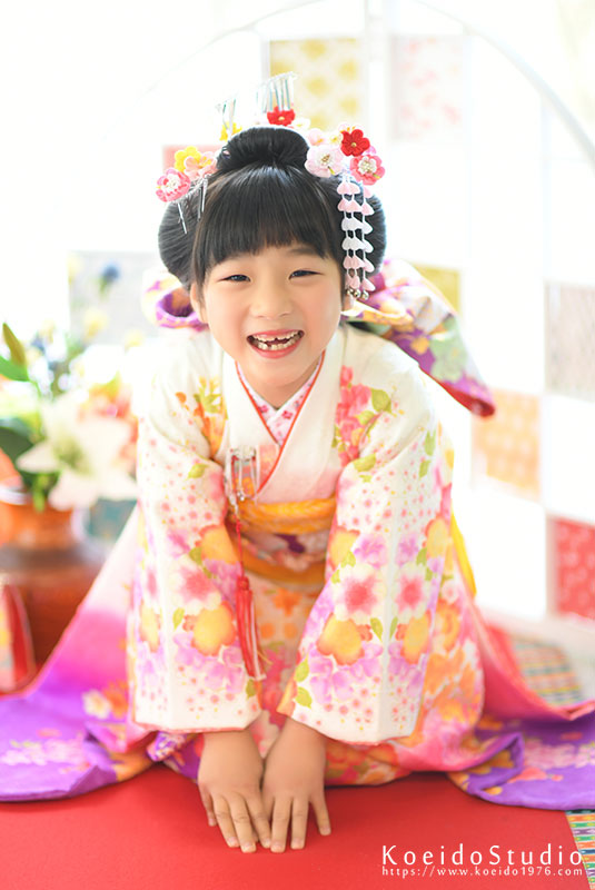 正座をしたお辞儀ポーズをする日本髪の七五三7歳の女の子